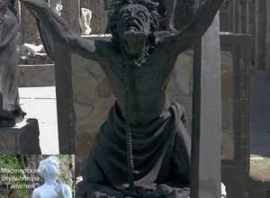 скульптура Иуды искариота на коленях с упавшим крестом веры